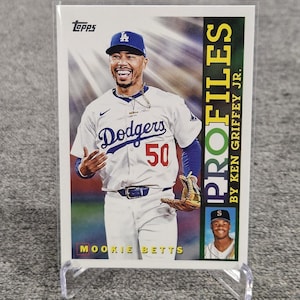 Puede incluir: Una tarjeta de béisbol con Mookie Betts de los Dodgers de Los Ángeles. La tarjeta muestra a Betts con su uniforme de los Dodgers, con el logotipo del equipo y el número 50 visibles. También incluye el texto "PROFILES BY KEN GRIFFEY JR."