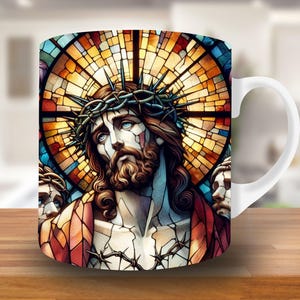 May include: White ceramic mug with a stained glass design featuring a depiction of Jesus Christ with a crown of thorns. The stained glass design is in shades of red, yellow, blue, and green.