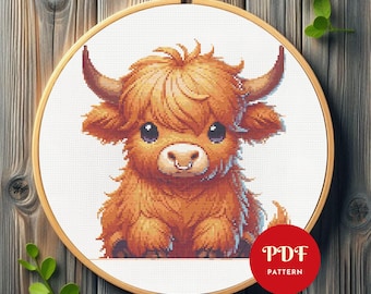 Op de afbeelding: Een kruissteekpatroon van een Schotse Hooglander in een houten borduurring. De koe heeft een pluizige, oranje-bruine vacht, grote ogen en gebogen hoorns. Een rode cirkel met de tekst "PDF PATTERN" staat rechtsonder.