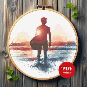Könnte beinhalten: Kreuzstichmuster einer Silhouette einer Person, die ein Surfbrett im Sonnenuntergang hält. Das Muster ist in einem runden Reifen und der Text "PDF PATTERN" ist in der unteren rechten Ecke sichtbar.