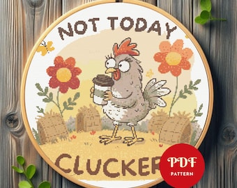 Puede incluir: Un patrón de punto de cruz en un aro de madera presenta una gallina de dibujos animados sosteniendo una taza de café. El texto dice "NOT TODAY CLUCKER" con flores y balas de heno. Un círculo rojo con "PDF PATTERN" está en la esquina inferior derecha.