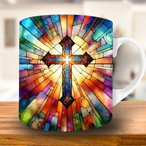 May include: White ceramic mug with a colorful stained glass design featuring a cross. The design is reminiscent of a church window.