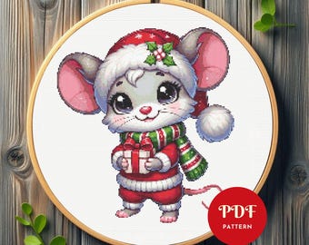 Op de afbeelding: Een kruissteekpatroon met een cartoonmuis in een kerstmuts, rood pak en groen-rode gestreepte sjaal, die een cadeau vasthoudt. Het ontwerp staat in een houten borduurring, met een rood "PDF PATTERN" label.