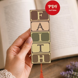 Op de afbeelding: Een rechthoekige kruissteek boekenlegger met het woord FAITH verticaal gestapeld in vijf afzonderlijke blokken. Elk blok heeft een unieke kleur, waaronder donkerbruin, lichtroze, olijfgroen, crème en bruin, met een rode kwast aan de onderkant.