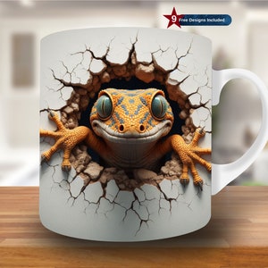 Op de afbeelding: Witte keramische mok met een kleurrijke gekko hagedis die uit een gebarsten muurontwerp kijkt. De gekko heeft blauwe ogen en oranje en gele markeringen.