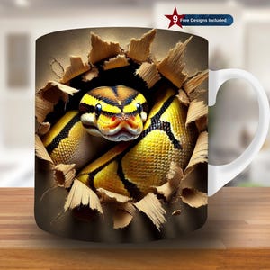 Puede incluir: Una taza de cerámica blanca con asa presenta un gráfico de una serpiente amarilla y negra rompiendo una superficie de madera. La cabeza de la serpiente es visible, con sus ojos y boca abiertos.