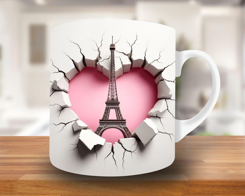 May include: White ceramic mug with a design of the Eiffel Tower breaking through a cracked wall with a pink heart behind it.