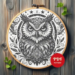 May include: A black and white cross-stitch pattern of an owl in a wooden embroidery hoop. The owl has detailed feathers and is surrounded by decorative elements. A red circle with the text "PDF PATTERN" is in the lower right corner.