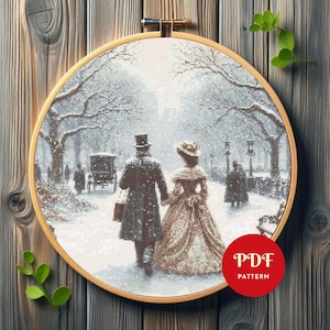 Op de afbeelding: Kruissteekpatroon van een stel dat in een besneeuwd park wandelt, omlijst in een houten borduurring. De scène toont een man en vrouw in historische kleding, hand in hand, met een paardenkoets op de achtergrond. Het patroon is gelabeld "PDF PATTERN".