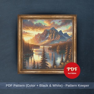 May include: A framed cross-stitch landscape featuring a mountain range, lake, and trees under a sunset sky. The artwork is in shades of brown, orange, blue, and yellow. The frame is gold-colored. The image includes the text "PDF Pattern" and "PDF Pattern (Color + Black & White) - Pattern Keeper".