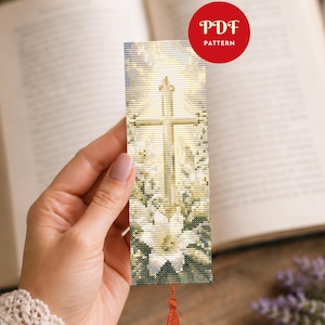 May include: A rectangular cross-stitch bookmark featuring a glowing golden cross centered above a large white lily flower. The design includes a soft, radiant light background and a small red circular badge in the corner with the text PDF PATTERN.