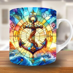 May include: White ceramic mug with a colorful stained glass design featuring an anchor, waves, and a sunset. The anchor is gold and blue with a rope detail.