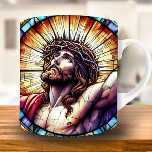 May include: White ceramic mug with a colorful stained glass design of Jesus Christ wearing a crown of thorns. The design features a vibrant mix of red, yellow, blue, and purple.