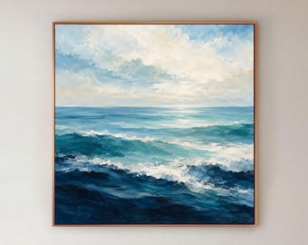 May include: A square oil painting depicting a seascape with deep blue ocean waves, white sea foam, and a light blue sky filled with soft clouds. The artwork is framed in a thin metallic border and hangs on a plain white wall.