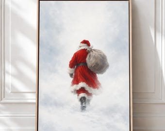 May include: A framed wall art print depicting a figure dressed in a red coat with white fur trim and a matching hat, walking away while carrying a large, tan sack over one shoulder against a backdrop of soft, white, cloudy mist.