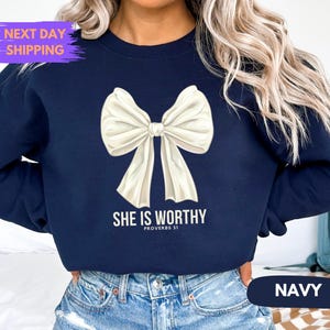 May include: Navy blue sweatshirt with a white bow and the text "She is worthy Proverbs 31".