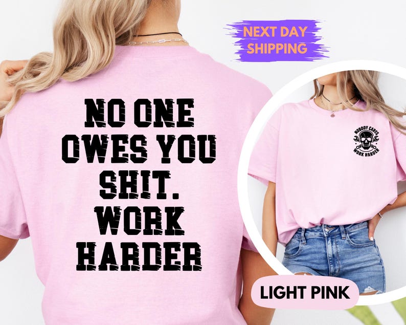 May include: Light pink t-shirt with the text "NO ONE OWES YOU SHIT. WORK HARDER" in bold black letters on the back. The front of the shirt features a small graphic of a skull and wrenches with the text "NOBODY CARES WORK HARDER".