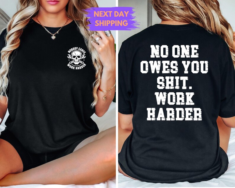 May include: Black t-shirt with white text and graphics. The front features a skull with crossed wrenches and the words "NOBODY CARES WORK HARDER". The back displays "NO ONE OWES YOU SHIT. WORK HARDER" in bold, block letters.