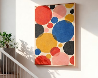 May include: A rectangular canvas painting in a light wood frame featuring a composition of overlapping circles in red, blue, yellow, black, and pink on a cream background. The artwork displays varied circle sizes and textured paint application.