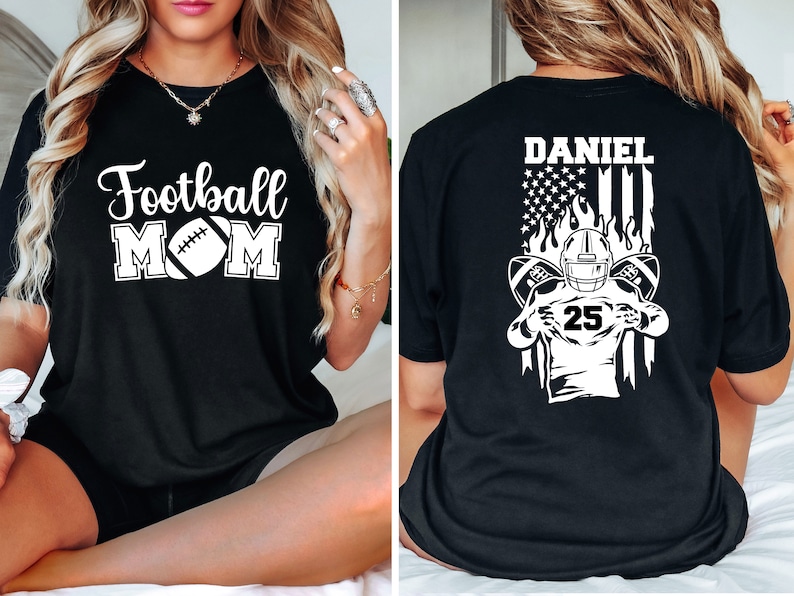 May include: Two black t-shirts with white text and graphics. The front of one shirt says "Football Mom" with a football graphic. The back of the other shirt says "Daniel" with an American flag and a football player graphic.