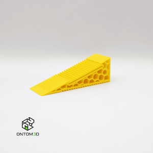 Puede incluir: Una cuña de color amarillo brillante con una superficie superior estriada y un lateral con patrón de panal. La cuña está diseñada con una base plana y una altura que aumenta gradualmente. El logotipo "ONTOM3D" es visible en la esquina inferior izquierda.