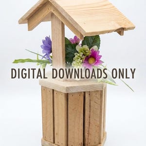 May include: A wooden wishing well planter with a gabled roof and vertical slat construction, containing artificial purple and white flowers with green leaves. The text DIGITAL DOWNLOADS ONLY is printed in dark brown across the center.