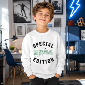 Könnte beinhalten: Ein weißes Langarm-Sweatshirt mit dem schwarzen Text SPECIAL EDITION in fetter Schrift, ergänzt durch die grünen, texturierten Zahlen 2016 und den Namen Anton in Schreibschrift, die mittig zwischen den Wörtern auf der Vorderseite stehen.