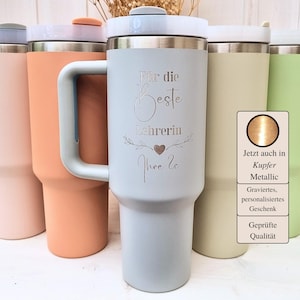 Könnte beinhalten: Eine Auswahl an isolierten Bechern in verschiedenen Pastellfarben, jeweils mit Griff und Deckel. Ein hellblauer Becher trägt den eingravierten Text "Für die Beste Lehrerin Ihre 20". Eine kleine Grafik mit deutschem Text ist ebenfalls sichtbar.