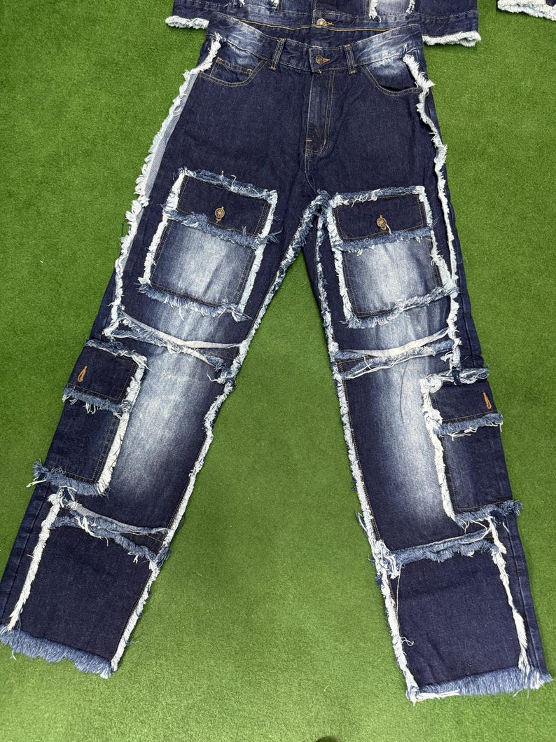 Peut inclure: Jean en denim bleu fonc&eacute; avec plusieurs poches plaqu&eacute;es et des bords blancs effiloch&eacute;s. Le jean a une conception classique &agrave; cinq poches avec des poches suppl&eacute;mentaires de style cargo. Le denim a un effet d&eacute;lav&eacute; et les bords sont effiloch&eacute;s.