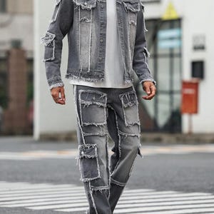Peut inclure: Ensemble veste et pantalon en jean gris. La veste a un col classique, une fermeture boutonn&eacute;e et des d&eacute;tails us&eacute;s. Le pantalon a plusieurs poches et une coupe d&eacute;contract&eacute;e. La tenue est port&eacute;e avec un t-shirt blanc et des baskets blanches.