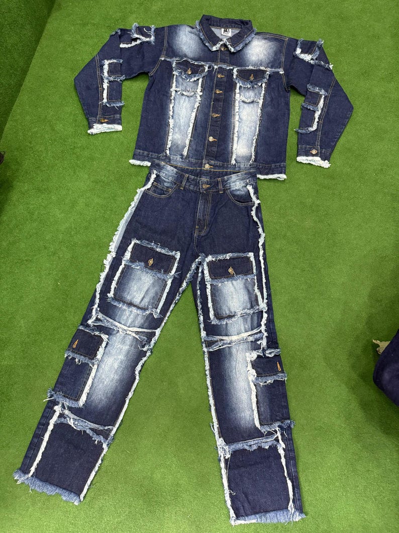Peut inclure: Un ensemble veste et jean en denim. Le denim bleu fonc&eacute; pr&eacute;sente des patchs d&eacute;lav&eacute;s bleu clair et des bords effiloch&eacute;s. La veste a une fermeture boutonn&eacute;e et le jean des poches cargo.