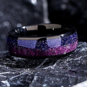 May include: A black tungsten carbide ring with a purple and blue glitter inlay. The ring has a polished finish and is designed to be durable and long-lasting.