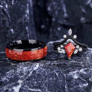 May include: A black wedding band with red glitter inlay and a black ring with a red gemstone and white accents.