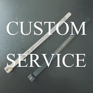 May include: Two measuring tapes, one white and one black, are crossed over each other on a gray surface. The white tape has numbers and the text "SIZE HALF SIZES" printed on it. The black tape has the alphabet printed on it. The text "CUSTOM SERVICE" is printed in white letters on a black background.