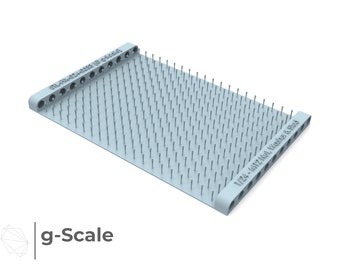 Könnte beinhalten: Eine hellblaue Plastik-Pinwand mit Reihen kleiner Pins. Die Tafel hat Text an den Seiten, der "g-Scale 1/24 - 1/622 Not War & 500g" lautet.