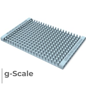 Puede incluir: Una herramienta de plástico azul claro con una cuadrícula de pequeños bultos redondos en relieve. La herramienta está etiquetada "1/24 1/35 Bolt Heads & Washers".