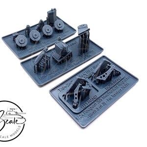 Op de afbeelding: Een set van 1/24 schaalmodel auto onderdelen voor een Peugeot 205. De onderdelen zijn gemaakt van grijs plastic en zijn gelabeld met de tekst "1/24 Peugeot 205 Mechanical Upgrades (Rali 3 of 3) - For Tamiya 24054", "TAM-240 16-CIG COOLERS", "LEFT HAND" en "RIGHT HAND".
