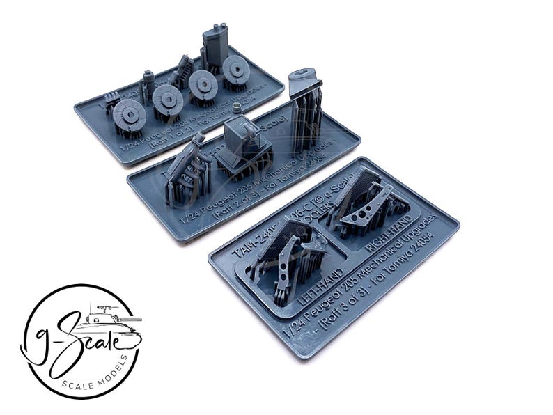 Op de afbeelding: Een set van 1/24 schaalmodel auto onderdelen voor een Peugeot 205. De onderdelen zijn gemaakt van grijs plastic en zijn gelabeld met de tekst "1/24 Peugeot 205 Mechanical Upgrades (Rali 3 of 3) - For Tamiya 24054", "TAM-240 16-CIG COOLERS", "LEFT HAND" en "RIGHT HAND".