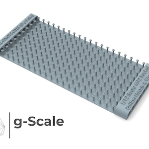 Puede incluir: Una lámina de plástico gris con una cuadrícula de pequeños tornillos, etiquetada "1/12 Scale (M12 Sockel Button Heads & Washer". La lámina está diseñada para la construcción de modelos y es parte de la marca g-Scale.