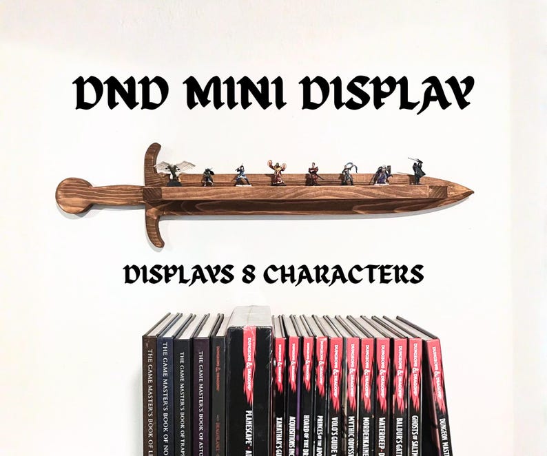 May include: A dark brown wooden wall shelf shaped like a sword, featuring a flat ledge for holding small figurines. The text DND MINI DISPLAY and DISPLAYS 8 CHARACTERS is printed above and below the shelf, which is mounted above several books.