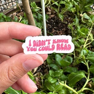 May include: A white sticker with pink lettering that reads "I didn't know you could read".