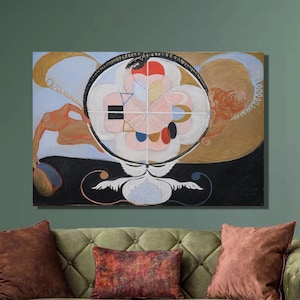 以下が含まれることがあります： 中央に円形のデザインが施された抽象画。円は4つのセクションに分かれており、それぞれ異なる色とパターンになっています。絵画は額装され、緑色の壁に緑色のソファの上にかけられています。