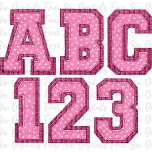 Puede incluir: Letras y números de fieltro rosa con lunares blancos. Las letras son A, B y C. Los números son 1, 2 y 3. Las letras y los números están en una fuente de estilo universitario.