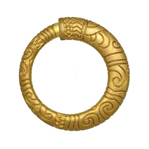 May include: A gold-toned, circular bracelet with detailed embossed patterns. The bracelet displays repeating scroll and geometric designs. The overall style is ornate and detailed, with a vintage or antique appearance.