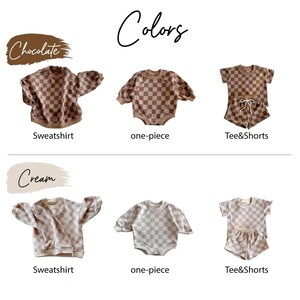 May include: A display of children's clothing sets in two color schemes: chocolate and cream. Each set includes a sweatshirt, one-piece, and tee and shorts. The clothing features a checkered pattern.