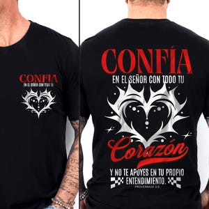 May include: Black t-shirt with the word "CONFIA" in red above a white heart design. The front of the shirt has the same design, with the text "EN EL SE&Ntilde;OR CON TODO TU". The back has additional text in Spanish.