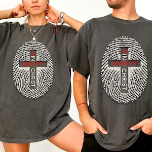 May include: Two gray t-shirts with a fingerprint design and the text "In Identity In Christ" printed on the front.