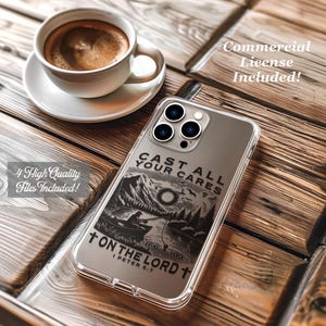 May include: A clear phone case with a black graphic of a fisherman on a lake, mountains, and the text "CAST ALL YOUR CARES ON THE LORD" and "I PETER 5:7". A cup of coffee sits on a saucer in the background.