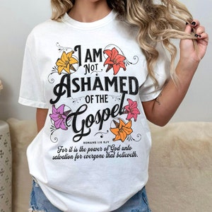 May include: White t-shirt with a floral design and the text "I am not ashamed of the Gospel" with a Bible verse reference.