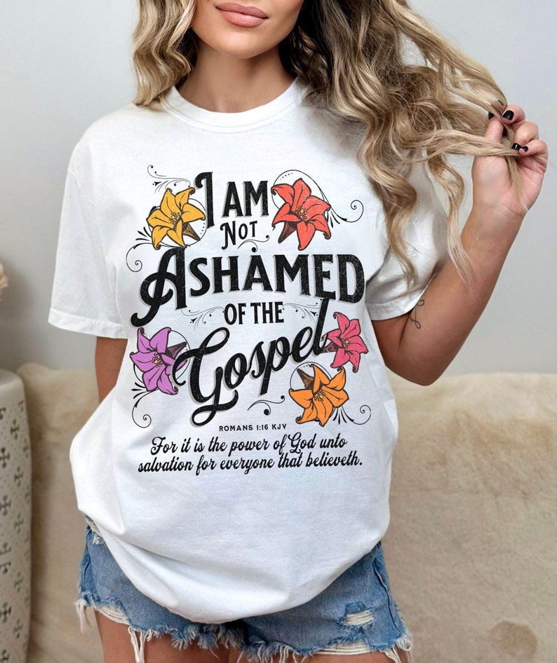 May include: White t-shirt with a floral design and the text "I am not ashamed of the Gospel" with a Bible verse reference.